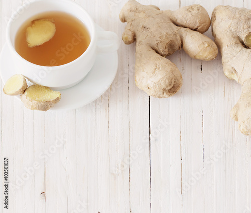 Ginger tea in a white cup on wooden background