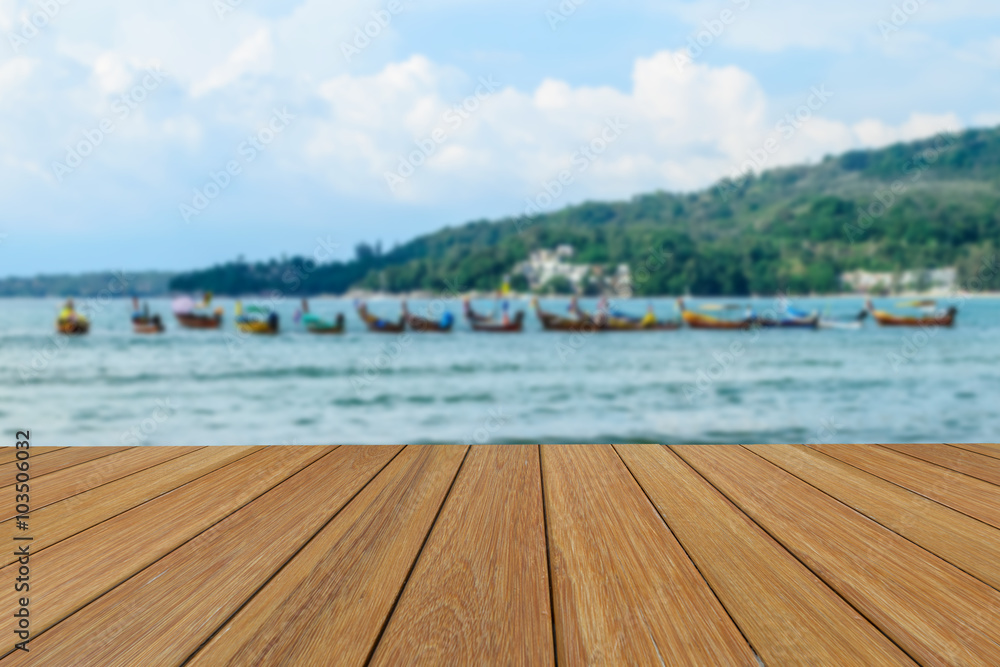 Obraz premium Wood table top on blurred beach background with long tail boat for presentation product.