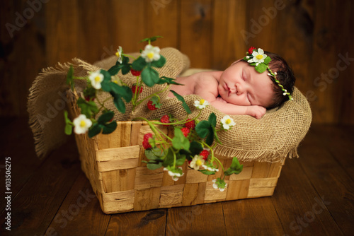 Obraz na plátně Newborn baby girl has sweet dreams in strawberries