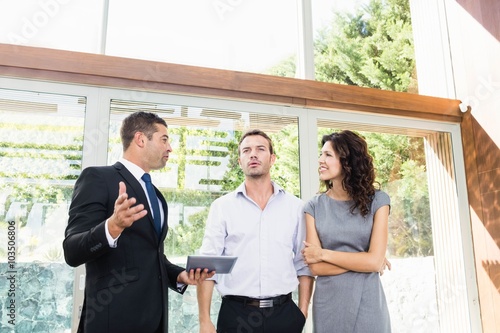 Real-estate agent showing couple new home photo