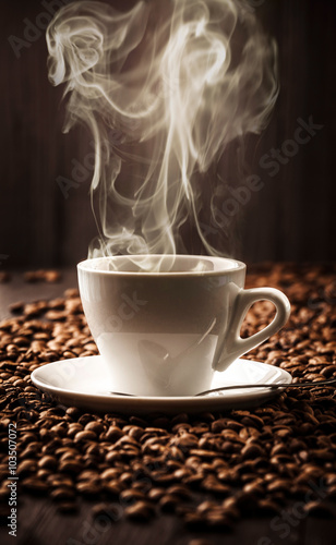 Hot cup of coffee on beans background