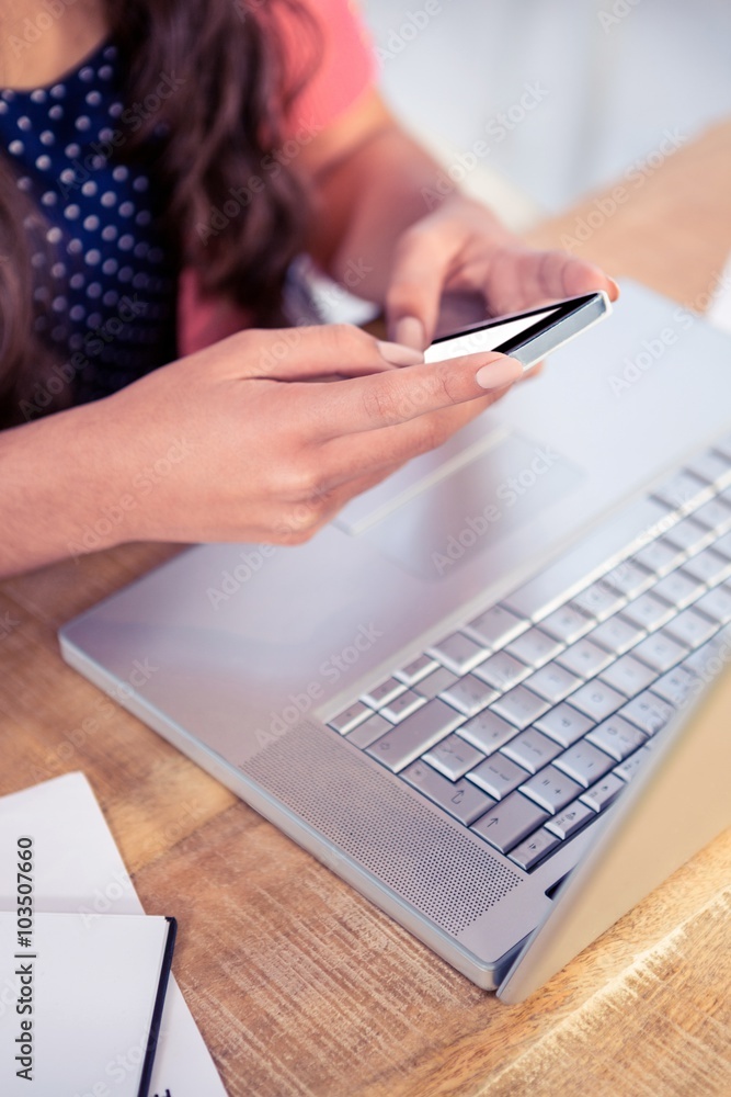 Businesswoman holding smartphone while sitting on Businesswoman holding smartphone while sitting on