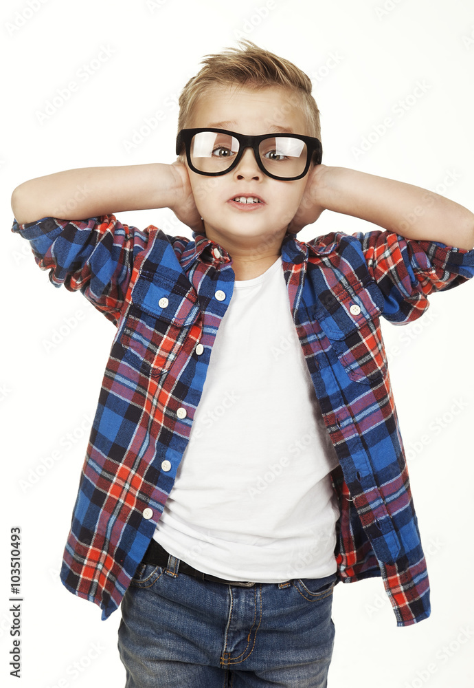 Funny child.fashionable little boy in glasses, jeans, white t-shirt and plaid shirt.stylish kid in sport shoes. fashion children closes his ears hands Funny child.fashionable little boy in glasses, jeans, white t-shirt and plaid shirt.stylish kid in sport shoes. fashion children closes his ears hands