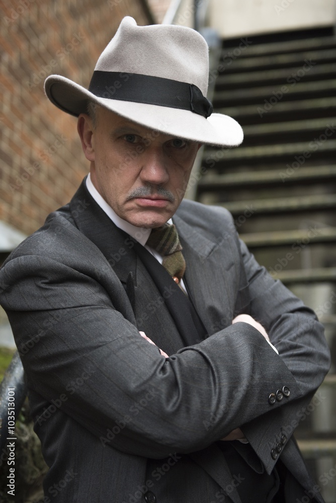 Vertical image of a mature man dressed as a 1940s gangster. looking into the camera. Vertical image of a mature man dressed as a 1940s gangster. looking into the camera.