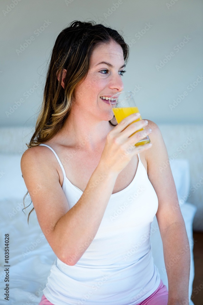 smiling woman driinking a glass of orange juice smiling woman driinking a glass of orange juice