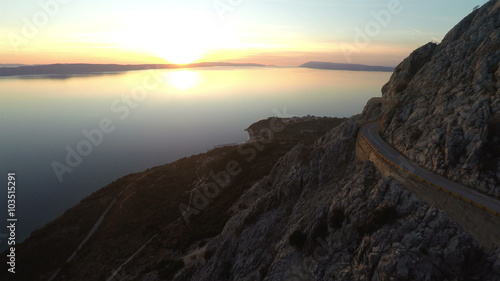 Aerial view of scenic mountain road with sea view in sunset