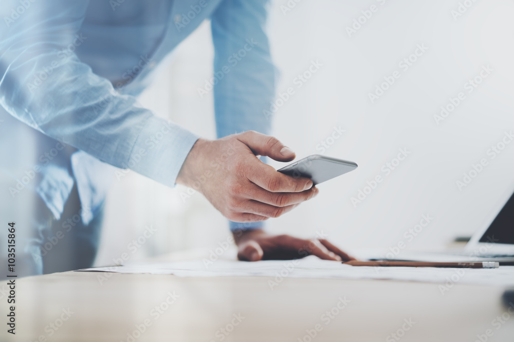 Photo of generic design smart phone holding in businessman hands. Blurred background. Horizontal mockup Photo of generic design smart phone holding in businessman hands. Blurred background. Horizontal mockup