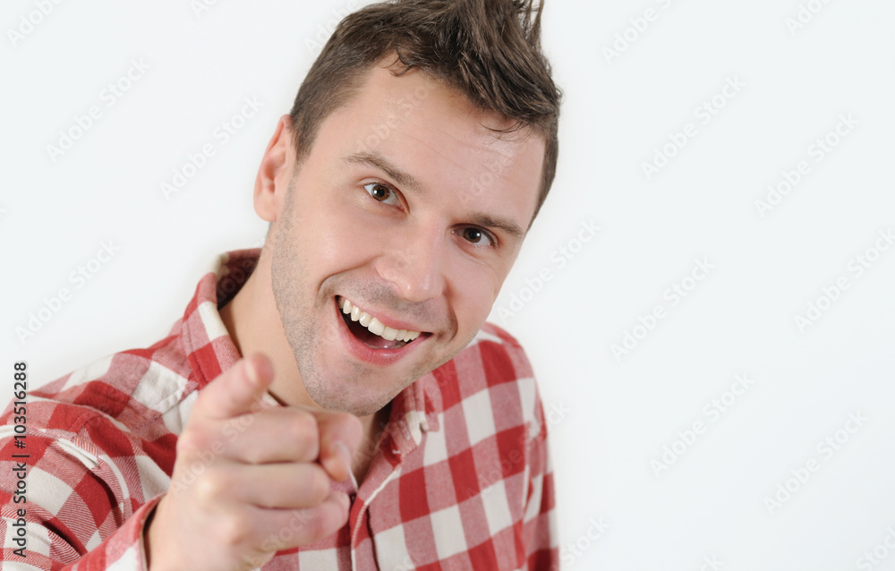 young man in hipster shirt pointing his finger at the camera and standing against white background young man in hipster shirt pointing his finger at the camera and standing against white background