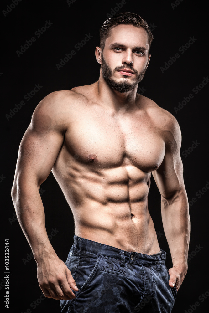 attractive bodybuilder sportsman shows perfect body muscles on b