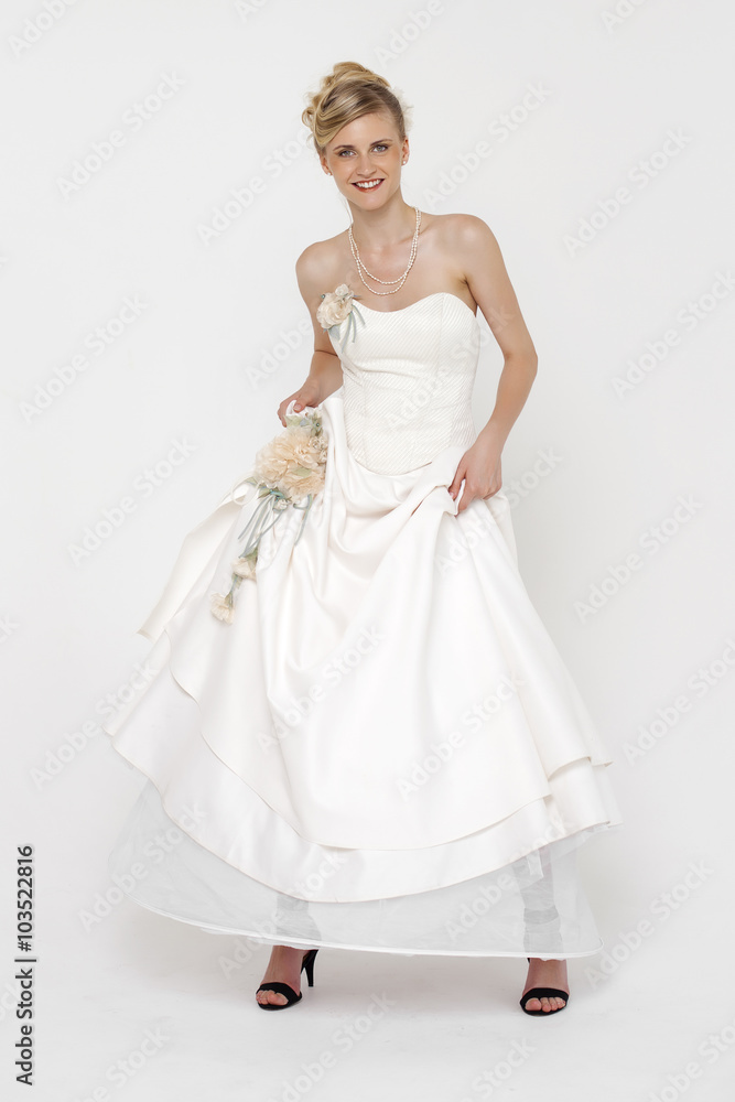 Portrait of gorgeous bride wearing wedding dress over grey backg