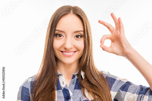 Portrait of attractive cheerful girl gesturing "OK"