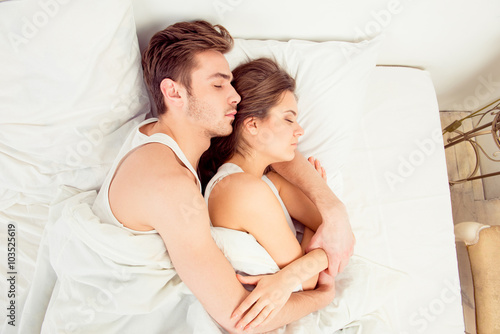 Young couple in love sleeping in the bedroom, top view photo