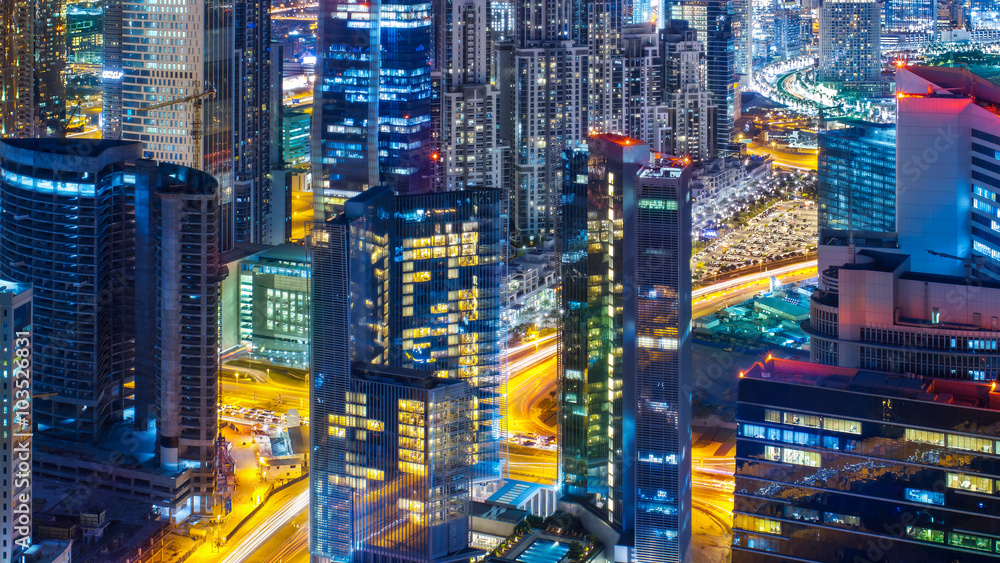 Fantastic rooftop view of a big modern city architecture at night with roads. Business bay, Dubai, United Arab Emirates. Fantastic rooftop view of a big modern city architecture at night with roads. Business bay, Dubai, United Arab Emirates.
