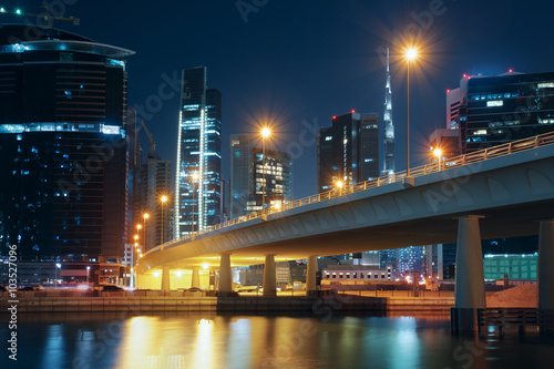 Dubai nighttime skyline with modern buildings, street lights and a bridge. Downtown Dubai, UAE.  photo