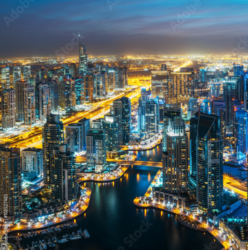 Fantastic rooftop skyline: illuminated architecture of a big city. Dubai Marina by night, United Arab Emirates. © Funny Studio