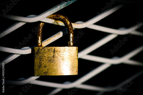 close up of golden lock on bridge