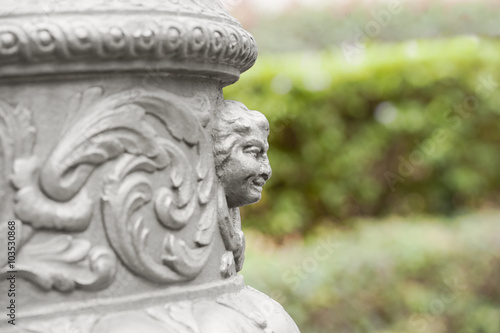 Fragment of decorative head column sculpture on a blurred background