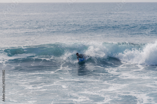 Bodyboarding and surfing in the waves of the Atlantic in front of the island La Gomera. A short light type of surfboard ridden in a prone position photo