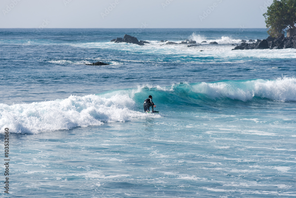 Bodyboarding and surfing in the waves of the Atlantic in front of the island La Gomera. A short light type of surfboard ridden in a prone position Bodyboarding and surfing in the waves of the Atlantic in front of the island La Gomera. A short light type of surfboard ridden in a prone position
