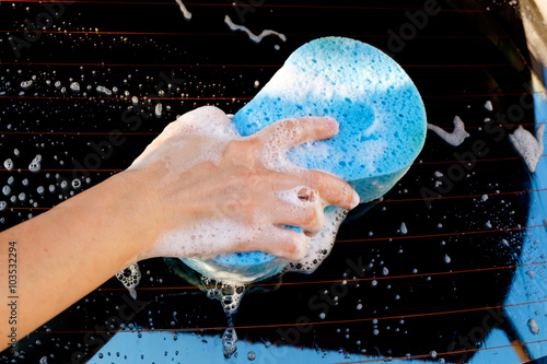 close up of hand washing a car with sponge and soap