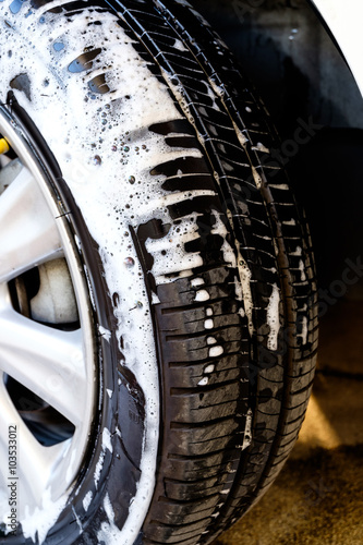 close up washing a car tire with soap