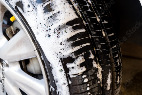 close up washing a car tire with soap