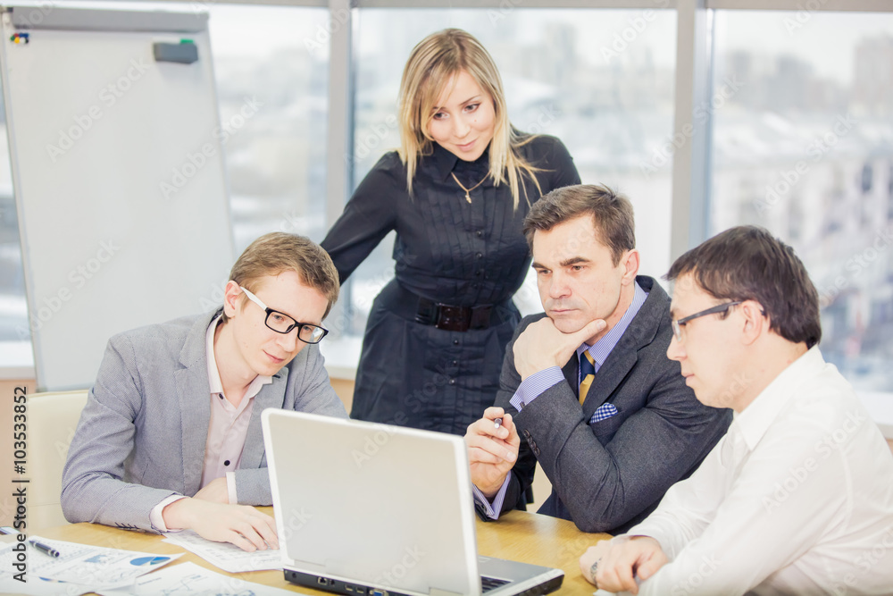 a few businessmen or colleagues look at the monitor and communicate