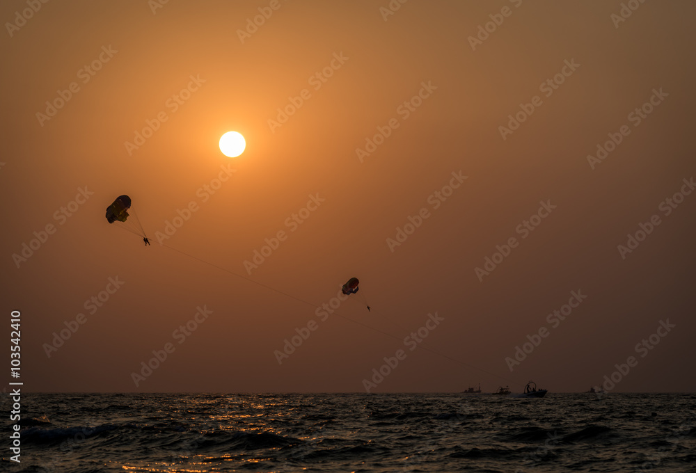 Couples parasailing during sunset in the Indian city of Goa