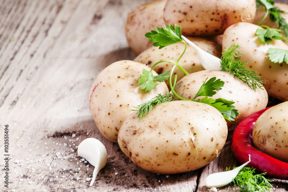 Fresh spring potatoes with spices on the old wooden background i Fresh spring potatoes with spices on the old wooden background i