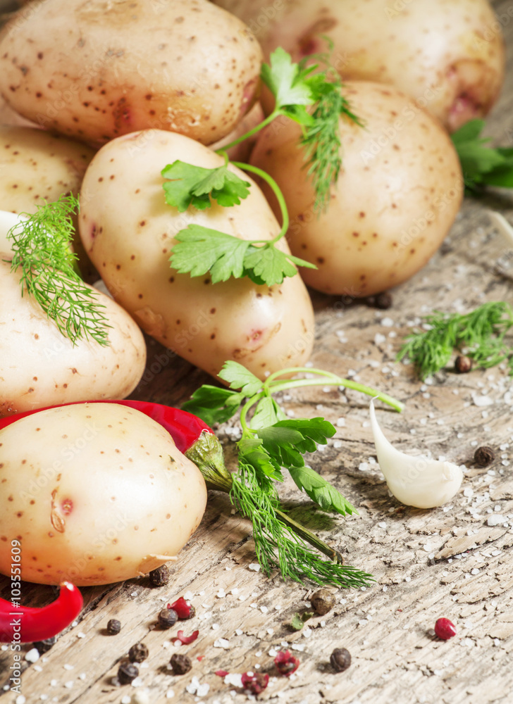 Fresh spring potatoes with spices on the old wooden background i Fresh spring potatoes with spices on the old wooden background i