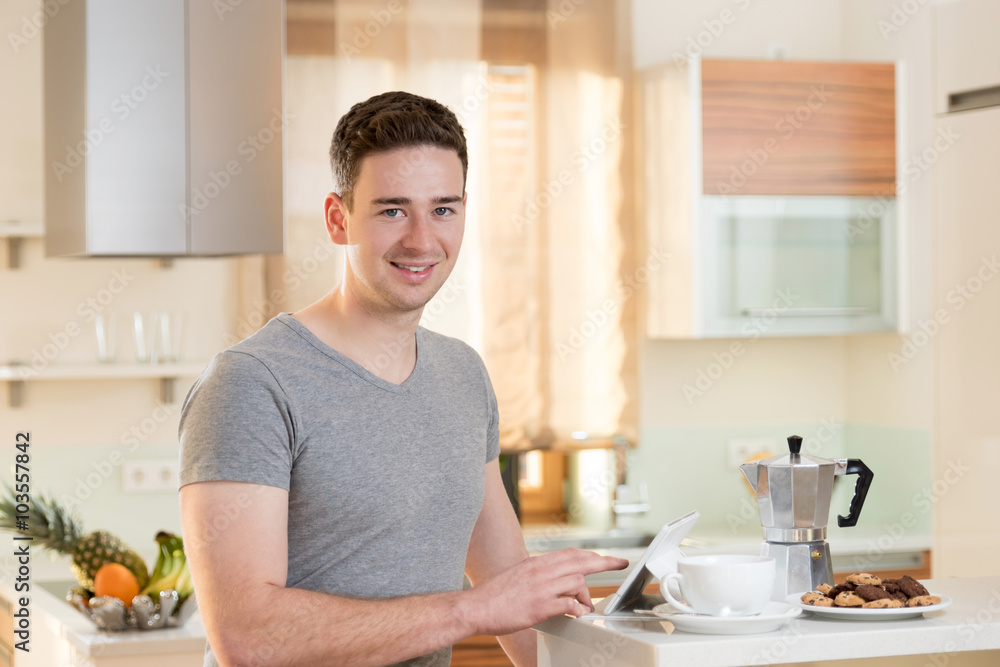 Junger Mann macht Kaffeepause und surft mit seinem Tablet Junger Mann macht Kaffeepause und surft mit seinem Tablet