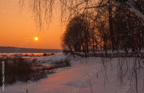 Winter landscape with sunset over the forest
