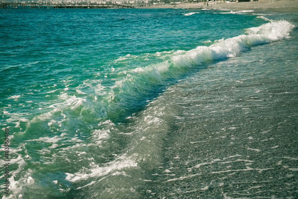 Wave on the pebble coast of sea. Selective focus. Toned