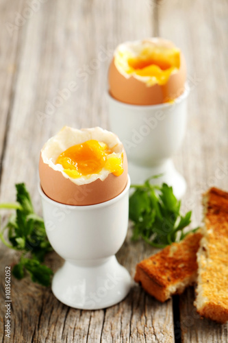 Boiled egg with toasts on a grey wooden table