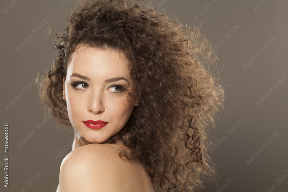 beautiful girl with long curly hair on a gray background beautiful girl with long curly hair on a gray background