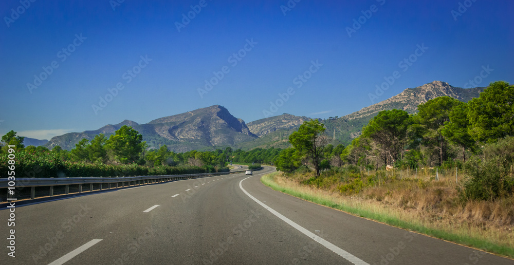 Highway through coastal Foothills and mountains of Spain.  Sunshine on highways running through the land on the edges of continental Europe in Spain. Road to Madrid.