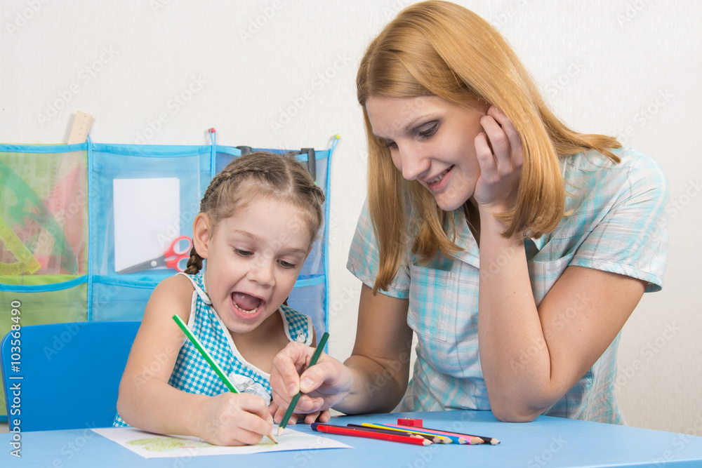 Five-year girl and young mother having fun drawing happy drawing with crayons Five-year girl and young mother having fun drawing happy drawing with crayons