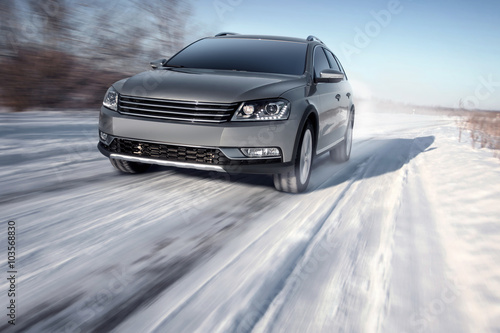 Gray modern car drive speed on road at winter daytime © Ivan Kurmyshov