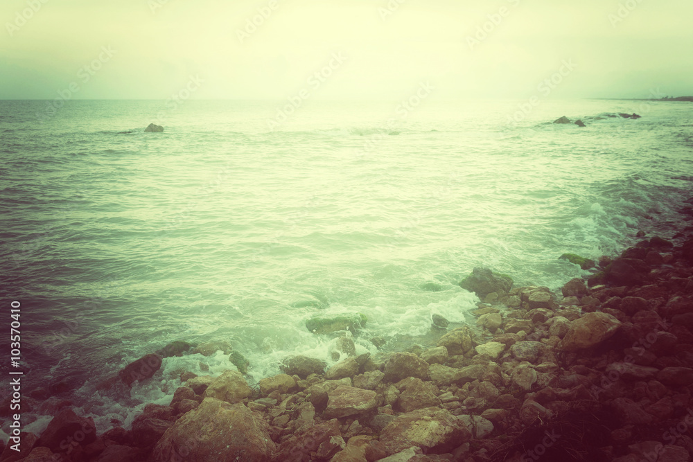 Rocky coast and stormy sea in green glow Rocky coast and stormy sea in green glow
