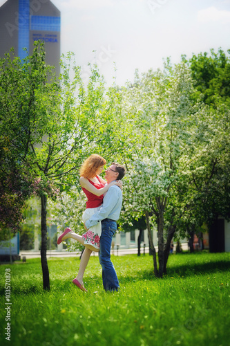 young couple walking in the blossoming spring garden