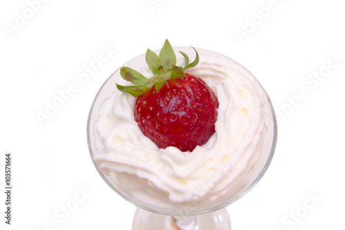 Glass with strawberry and cream on a white background seen up close