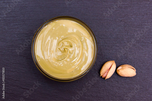 Pistachio cream in bowl on slate top view from above