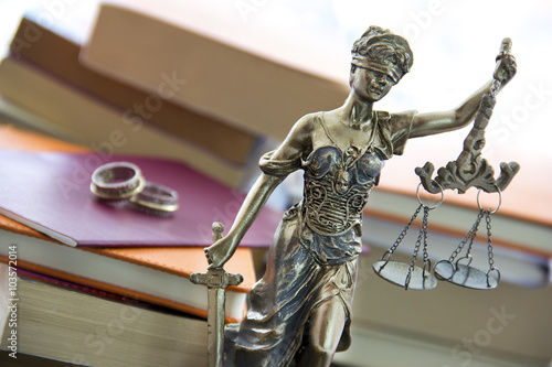 Family law. Justice statue with sword and scale and marriage certificate