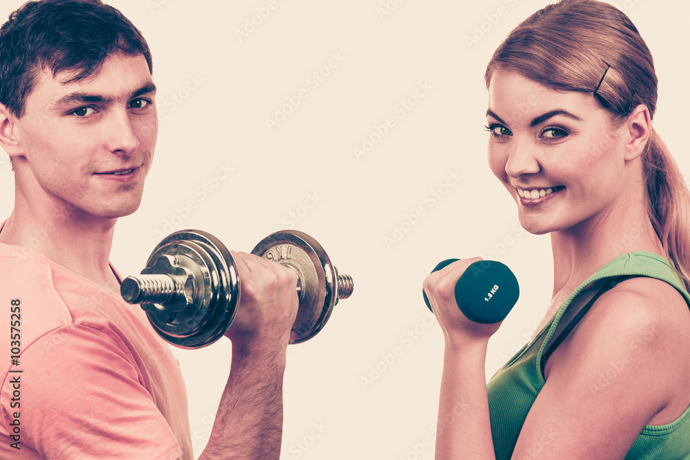 Couple exercising with dumbbells lifting weights Couple exercising with dumbbells lifting weights