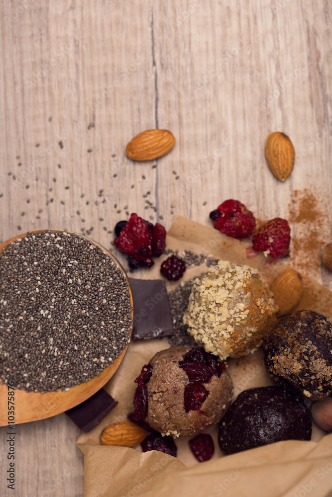 Combination of chia seeds, raw, homemade sweet balls on wooden b Combination of chia seeds, raw, homemade sweet balls on wooden b