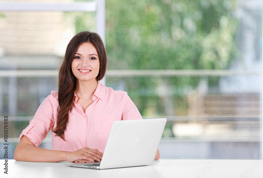 Young woman working with laptop in the office Young woman working with laptop in the office