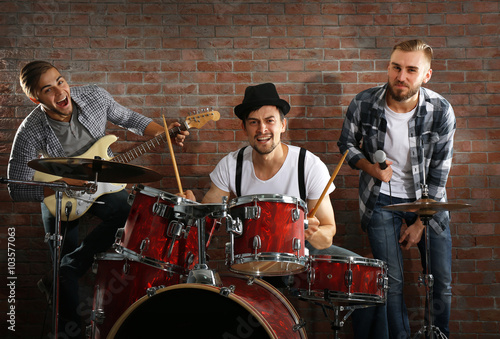 Musicians playing the drums on brick wall background © Africa Studio