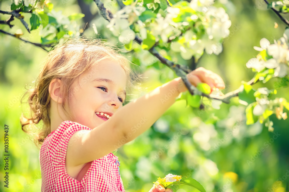 Happy little girl playing in spring apple tree garden Happy little girl playing in spring apple tree garden