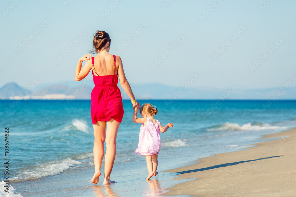 Mother and little daughter walking on the beach Mother and little daughter walking on the beach