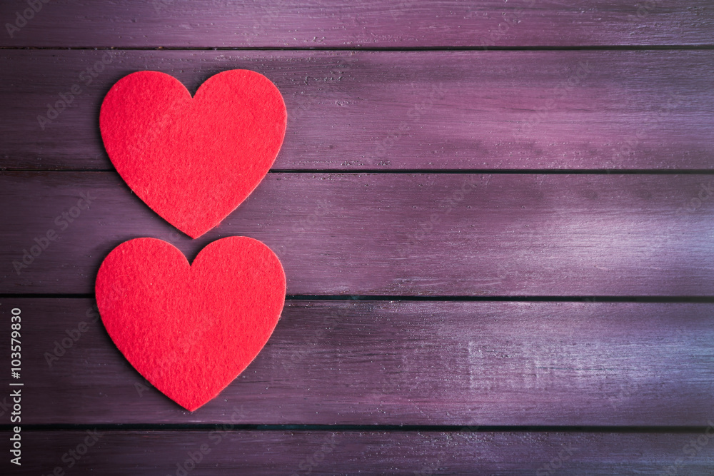 Red felt hearts on purple wooden background Red felt hearts on purple wooden background